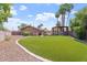 The backyard features artificial turf, a built in fire pit, and a patio with BBQ at 2727 W Ocaso Cir, Mesa, AZ 85202