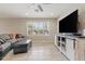 Cozy living room featuring a large window, wood-look floors, and a ceiling fan at 2727 W Ocaso Cir, Mesa, AZ 85202
