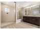 Bathroom featuring a walk-in shower, dual sink vanity, modern lighting, and neutral tile flooring at 28263 N Welton Pl, San Tan Valley, AZ 85143
