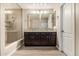 Primary bathroom showcasing a tiled walk-in shower, dual sink vanity, and decorative backsplash at 28263 N Welton Pl, San Tan Valley, AZ 85143