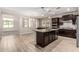 Spacious kitchen featuring wood look flooring, dark cabinetry and a center island with seating at 28263 N Welton Pl, San Tan Valley, AZ 85143