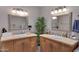 Bathroom with double sink vanity, tile countertop and backsplash, two large mirrors, and a decorative plant at 3007 N 84Th Pl, Scottsdale, AZ 85251