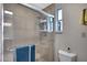 Modern shower with glass doors, rain shower head, tiled walls, and a built-in shelf at 3007 N 84Th Pl, Scottsdale, AZ 85251