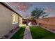 Lush backyard with manicured lawn, a fire pit, and seating, offering a private outdoor retreat at 32096 N 132Nd Dr, Peoria, AZ 85383