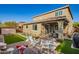 Spacious backyard features a covered patio, manicured lawn, and inviting fire pit area for relaxation at 32096 N 132Nd Dr, Peoria, AZ 85383