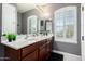 Well-lit bathroom features dual sinks with shuttered windows that provide great natural light at 32096 N 132Nd Dr, Peoria, AZ 85383