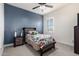 Charming bedroom with ceiling fan, neutral carpet, bed and nightstand on accent wall at 32096 N 132Nd Dr, Peoria, AZ 85383