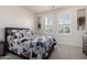 Bright bedroom featuring neutral walls, carpet, and comfortable bed with patterned bedding at 32096 N 132Nd Dr, Peoria, AZ 85383