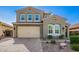 Attractive two-story home featuring a paver driveway, lush landscaping, and a two-car garage at 32096 N 132Nd Dr, Peoria, AZ 85383