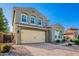 Charming two-story home showcasing a two-car garage, lush landscaping, and a welcoming brick driveway at 32096 N 132Nd Dr, Peoria, AZ 85383