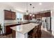 Spacious kitchen featuring an oversized island, dark wood cabinetry, granite countertops and stainless steel appliances at 32096 N 132Nd Dr, Peoria, AZ 85383