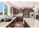 Modern kitchen showcasing granite counters, stainless steel appliances, and dark wood cabinets at 32096 N 132Nd Dr, Peoria, AZ 85383