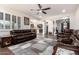 Spacious living room with hardwood floors, ceiling fan, and stylish leather furniture at 32096 N 132Nd Dr, Peoria, AZ 85383
