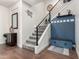 Modern staircase with metal railings, wood floors, and custom storage bench at 32096 N 132Nd Dr, Peoria, AZ 85383