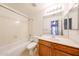 Bright bathroom features a bathtub, tile flooring, and a vanity with modern fixtures at 3545 W Glass Ln, Phoenix, AZ 85041