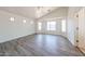Bedroom with wood-look flooring and a ceiling fan, illuminated by natural light streaming through windows at 3545 W Glass Ln, Phoenix, AZ 85041