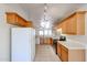 Spacious kitchen featuring wooden cabinets, laminate countertops, white appliances and tile flooring at 3545 W Glass Ln, Phoenix, AZ 85041