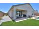 Cozy covered back patio with comfortable seating and an adjacent green area, perfect for outdoor relaxation at 38144 W San Clemente St, Maricopa, AZ 85138