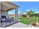 Landscaped backyard featuring a covered patio, seating area, artificial turf, and a sparkling swimming pool at 38144 W San Clemente St, Maricopa, AZ 85138