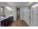 Modern bathroom with dual vanities, wood floors, and a glass-enclosed shower at 38144 W San Clemente St, Maricopa, AZ 85138