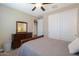 Cozy bedroom featuring a dresser with a mirror, a window, and a bed with a gray quilted bedspread at 38144 W San Clemente St, Maricopa, AZ 85138