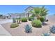 Well-maintained front yard with desert landscaping, including rocks, bushes, and palm trees at 38144 W San Clemente St, Maricopa, AZ 85138