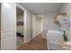 View of a hallway with tile floors, with the laundry room to the right and walk-in closet to the left at 38144 W San Clemente St, Maricopa, AZ 85138