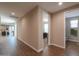 Hallway with wood-look tile flooring, leading to a bathroom, bedroom, and sliding glass doors at 38144 W San Clemente St, Maricopa, AZ 85138