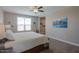 Bright bedroom with ceiling fan, carpet floors, and mountain view artwork at 38144 W San Clemente St, Maricopa, AZ 85138