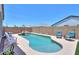 Sparkling backyard pool featuring a rock waterfall, surrounded by patio space with comfortable seating at 38144 W San Clemente St, Maricopa, AZ 85138