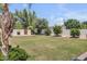 Expansive backyard with lush green lawn, mature trees, and a charming fence at 3924 E Roma Ave, Phoenix, AZ 85018