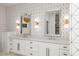 This bathroom features a double vanity with a white countertop and modern fixtures, complemented by geometric wallpaper at 3924 E Roma Ave, Phoenix, AZ 85018