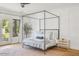 Inviting bedroom with a canopy bed, hardwood floors, and natural light at 3924 E Roma Ave, Phoenix, AZ 85018