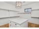 Well-organized walk-in closet with custom shelving, island, and modern lighting, ideal for efficient wardrobe management at 3924 E Roma Ave, Phoenix, AZ 85018