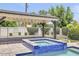 Inviting spa with an attached seating area covered by a wooden pergola with decorative lighting at 3924 E Roma Ave, Phoenix, AZ 85018