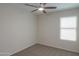 Cozy bedroom with neutral carpet, ceiling fan, and window for natural light at 40468 W Sanders Way, Maricopa, AZ 85138