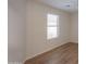 Bright bedroom with a large window, neutral walls, and wood-look floors, creating a cozy ambiance at 40468 W Sanders Way, Maricopa, AZ 85138