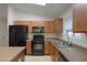 Kitchen featuring black appliances, modern cabinets, and tiled floors at 40468 W Sanders Way, Maricopa, AZ 85138