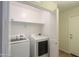 Functional laundry room with modern washer and dryer and ample storage at 40468 W Sanders Way, Maricopa, AZ 85138