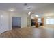 Open-concept living space features wood-look flooring, neutral tones, and seamless access to a modern kitchen at 40468 W Sanders Way, Maricopa, AZ 85138