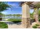 Park pavilion area with stone and pergola structure, seating and a beautiful lakeside view at 40468 W Sanders Way, Maricopa, AZ 85138