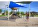 Community playground area with slides, climbing structures, and a shaded picnic area at 40468 W Sanders Way, Maricopa, AZ 85138