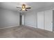 Bright bedroom featuring neutral carpet, gray walls, ceiling fan, and closet at 4380 W White Canyon Rd, San Tan Valley, AZ 85144