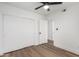 A bright bedroom features wood-look flooring, closet, and access to another room at 5230 E Brown Rd # 114, Mesa, AZ 85205