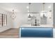 Modern kitchen boasts white cabinets, a large island with a sink, and stylish pendant lighting at 5230 E Brown Rd # 114, Mesa, AZ 85205