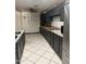 Functional kitchen with dark cabinetry, granite countertops, stainless steel appliances, and tile flooring at 608 W 2Nd Pl, Mesa, AZ 85201