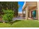 Landscaped backyard with lush green turf, mature trees, and a cozy covered patio area at 6510 S Hazelton Ln # 101, Tempe, AZ 85283