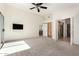 Large bedroom featuring carpeted floors, closet, ceiling fan and access to en suite bathroom at 6510 S Hazelton Ln # 101, Tempe, AZ 85283