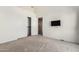 Bright bedroom with a TV on the wall and open closet doors and carpet at 6510 S Hazelton Ln # 101, Tempe, AZ 85283