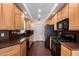Well-lit kitchen featuring wooden cabinets, granite countertops, and stainless steel appliances at 6510 S Hazelton Ln # 101, Tempe, AZ 85283